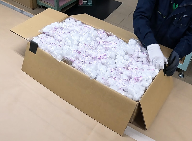長尺エンドレスベルトの上へ繭玉緩衝材を敷き詰める様子